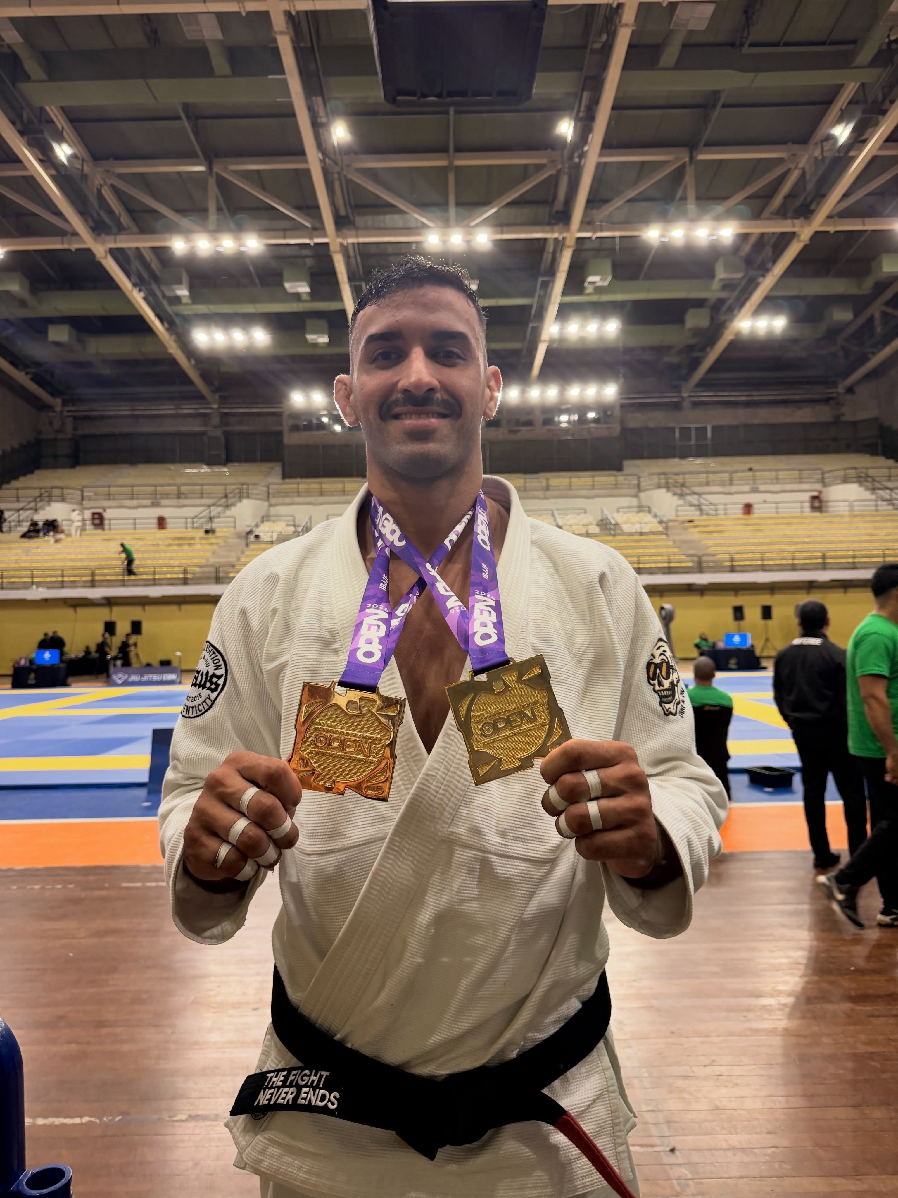 João Victor de kimono segurando duas medalhas de ouro no Rio Fall International Open